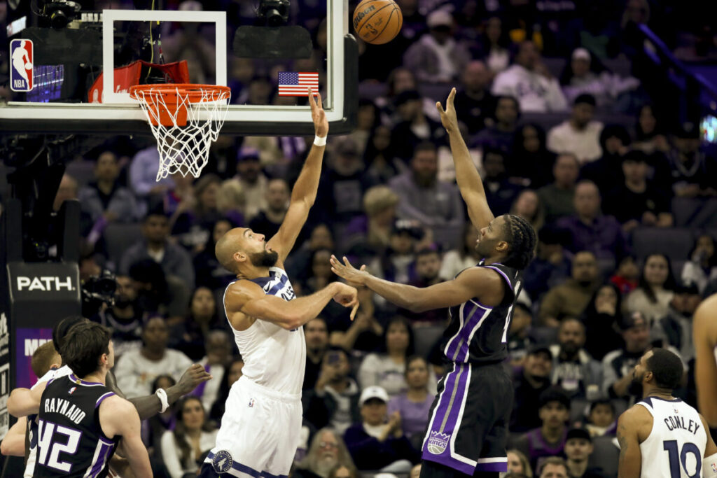 Precious Achiuwa floats the ball over Minnesota Timberwolves center Rudy Gobert