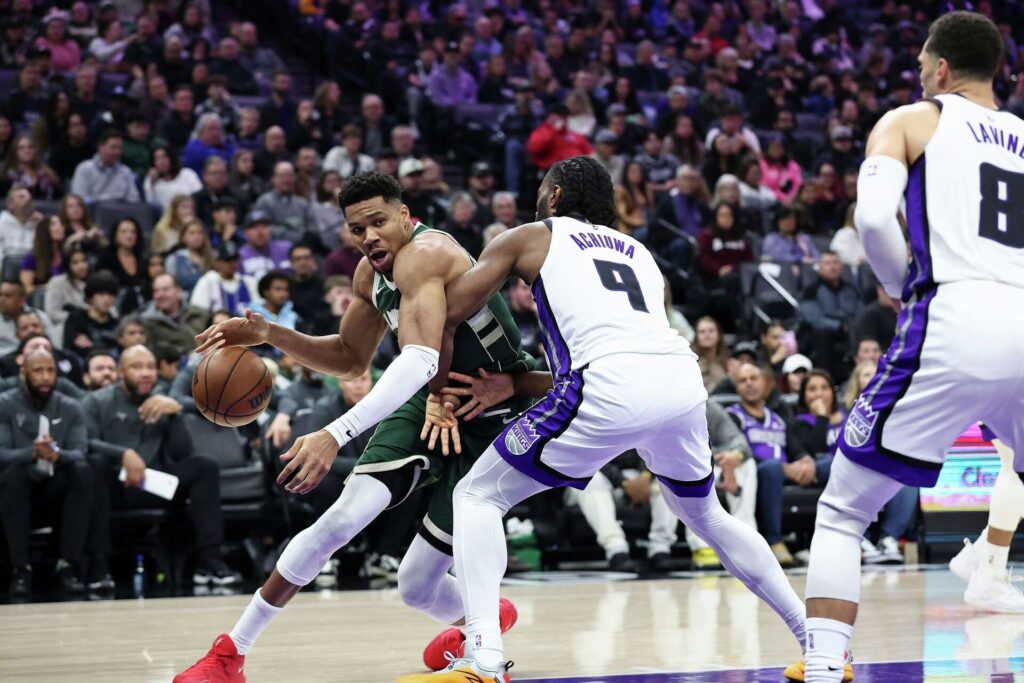 Precious Achiuwa defending against Bucks' Giannis Antetokounmpo